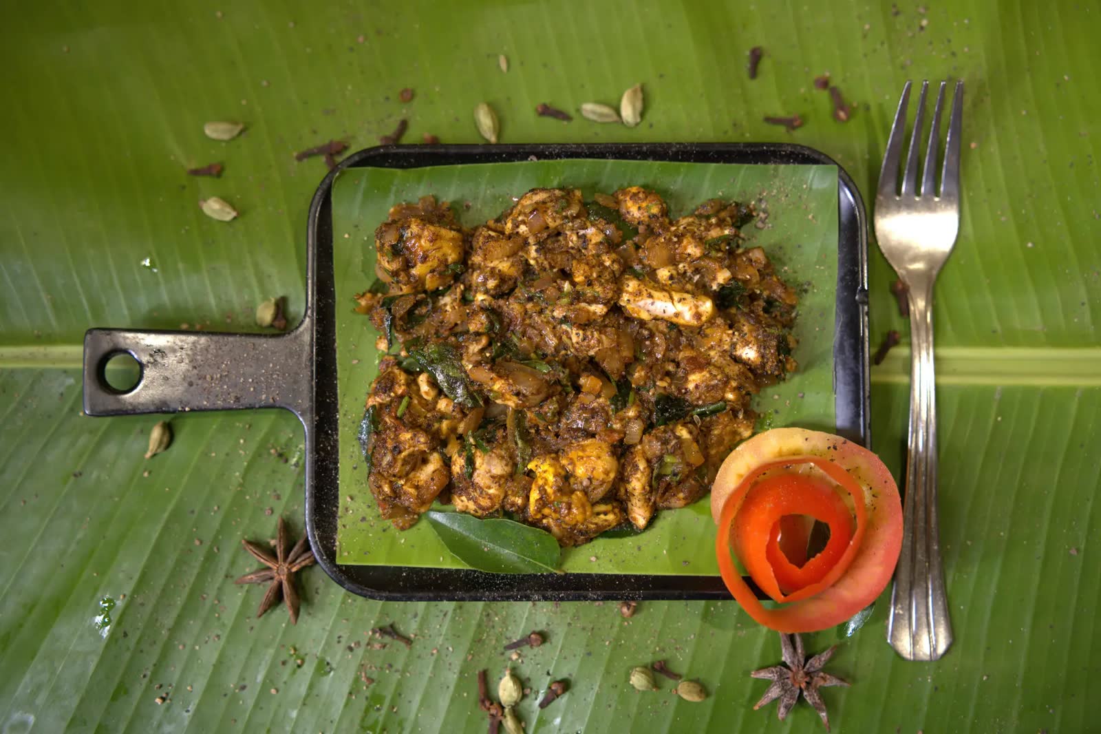Chicken Chettinad Fry served on a banana leaf